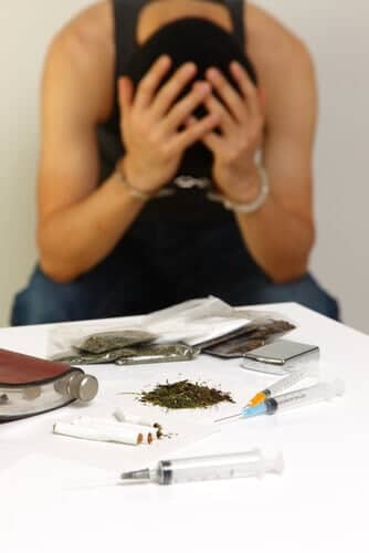 Man in front of a table covered in drugs.